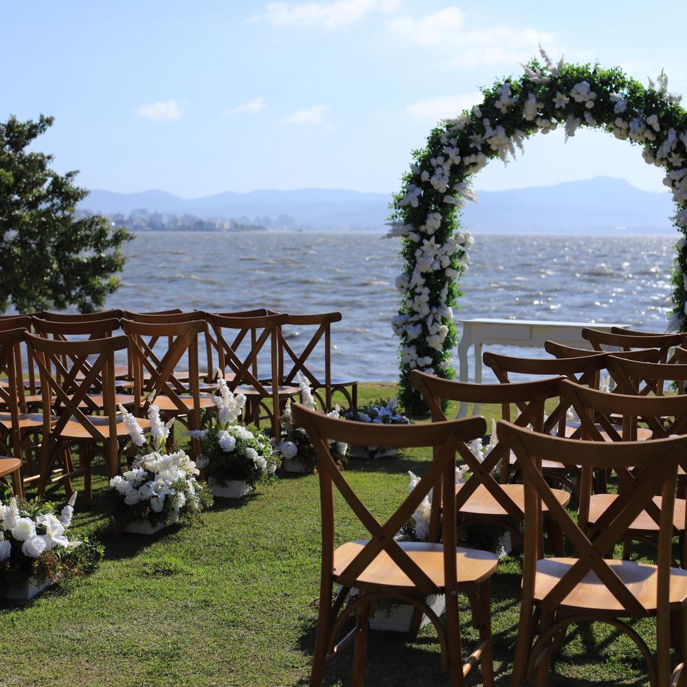 Arco de folhagem montado no gramado da Beira Mar, com a baía e os morros ao fundo