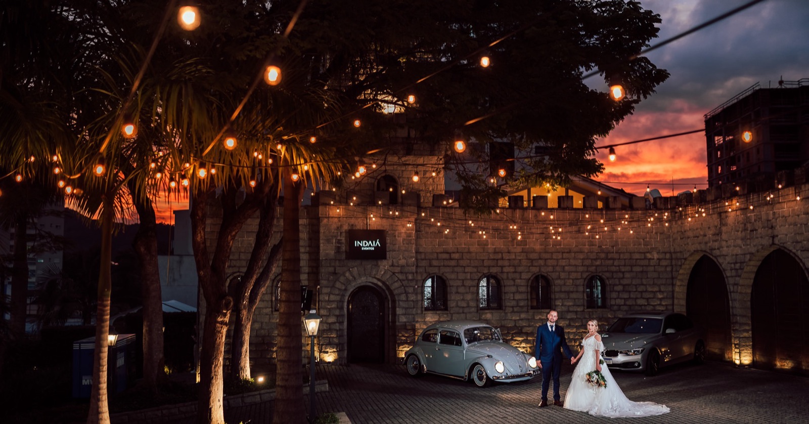 O castelo do Indaiá Eventos em Blumenau ao pôr do sol, com casal de noivos no pátio