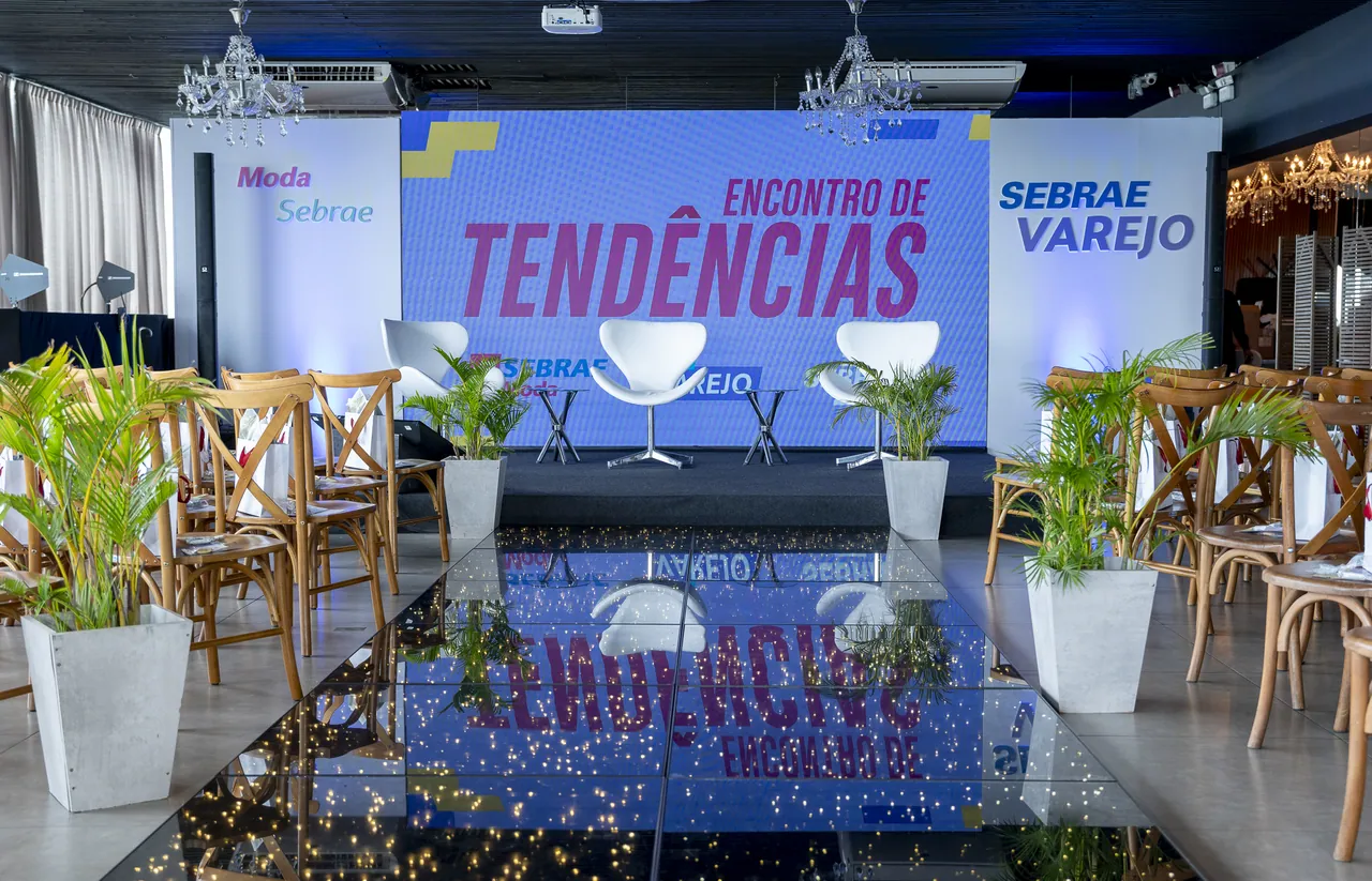 Palco e telão preparados para um encontro corporativo no Indaiá em Florianópolis, com cadeiras e corredor central espelhado.