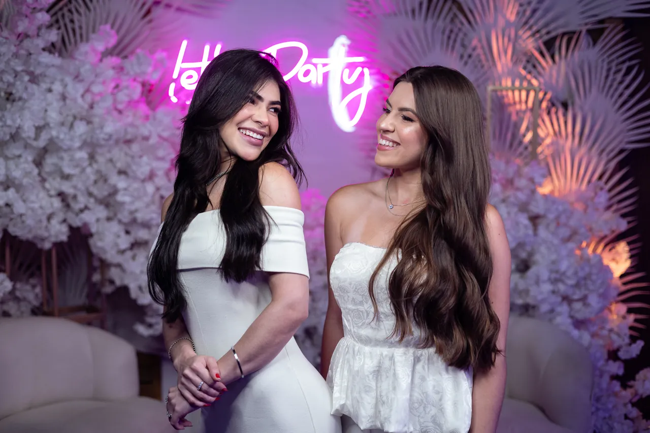 Duas convidadas sorrindo juntas na celebração.