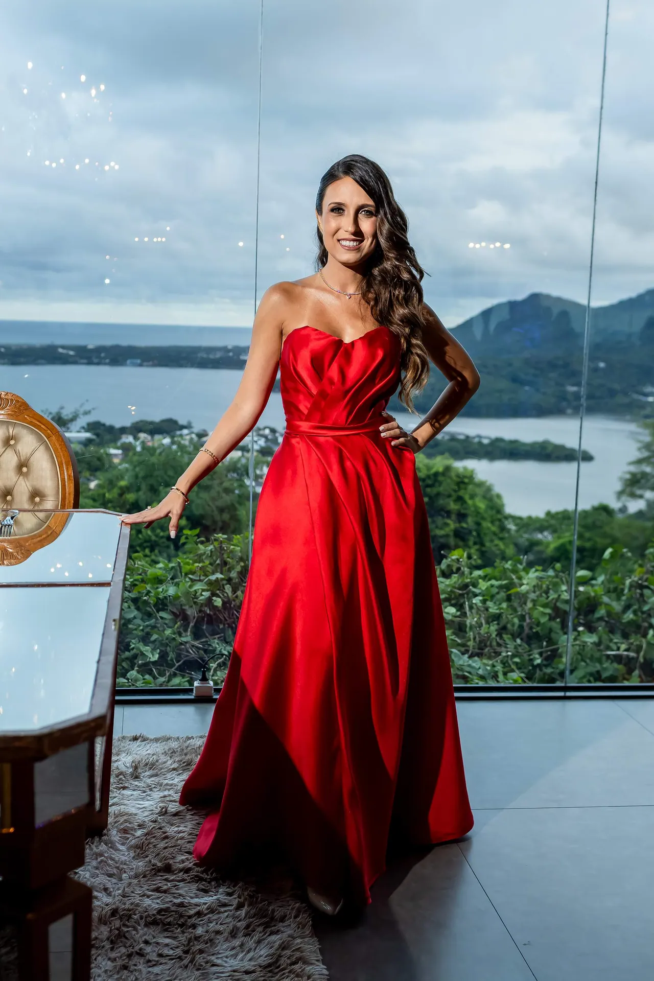 Formanda de vestido vermelho diante da vista da Lagoa, no Indaiá em Florianópolis.