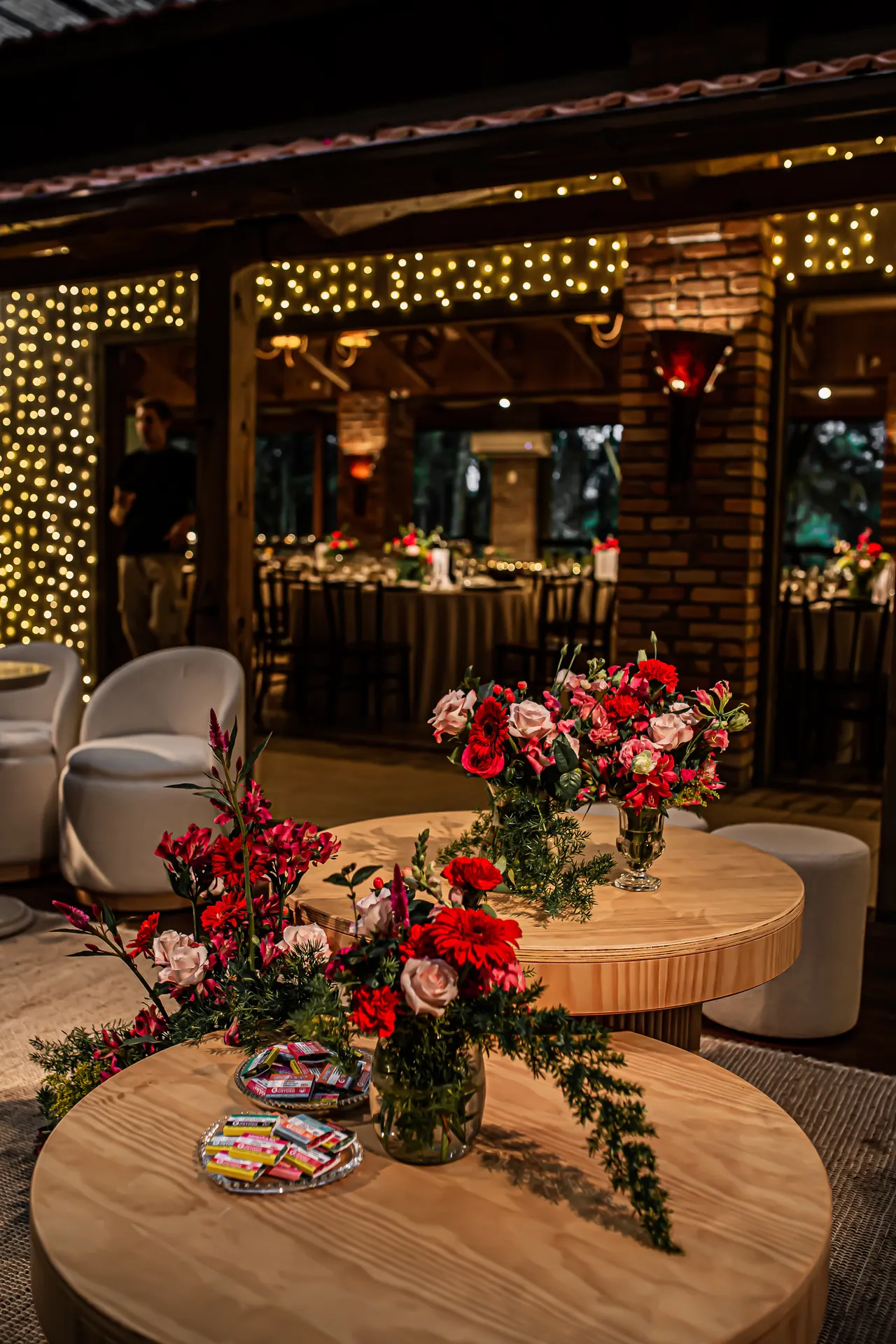 Lounge com flores vermelhas e iluminação acolhedora para uma formatura no Indaiá em Nova Veneza.