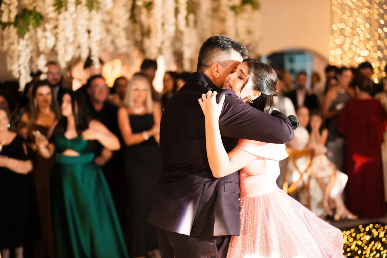 Debutante abraçada durante a celebração de seus 15 anos no Castelo Blumenau.